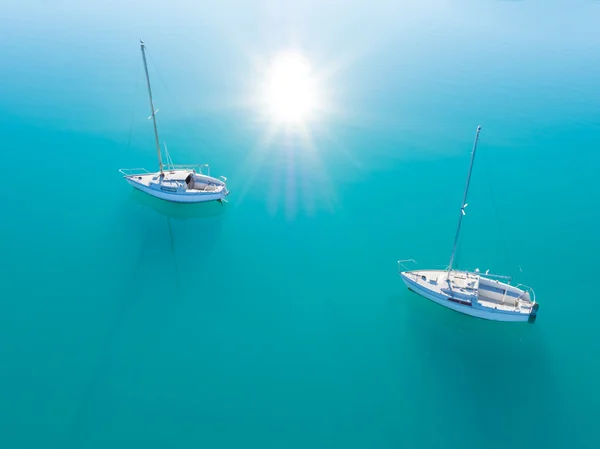 Flygfoto över två båtar sailling på azurblå vatten — Stockfoto