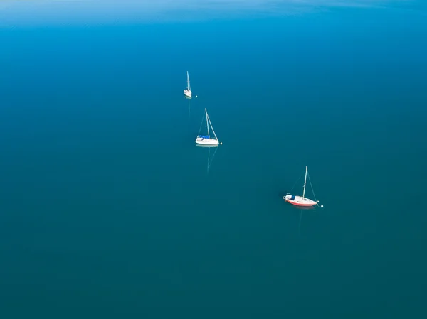 Αεροφωτογραφία του τρία σκάφη με ιστιοπλοϊκό στο γαλάζιο νερό — Φωτογραφία Αρχείου