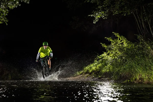 Montanha ciclista equitação em fluxo de floresta — Fotografia de Stock