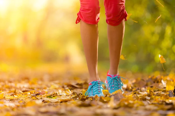 Gros plan des pieds d'un coureur courant dans les feuilles — Photo