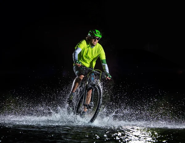 Ciclista de montaña salpicando agua — Foto de Stock