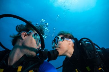 Dalgıçların birbirlerine su altında öpüşme