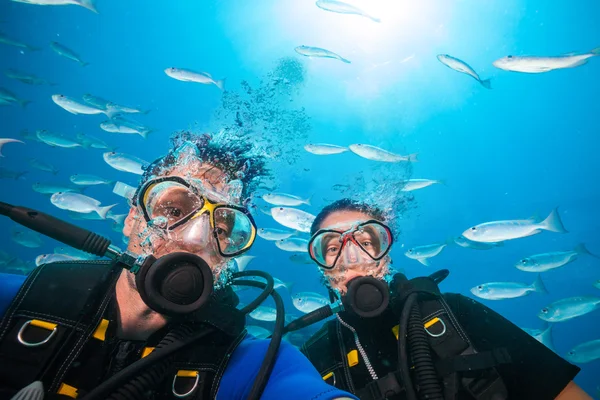 Duikers kijken camera onderwater — Stockfoto