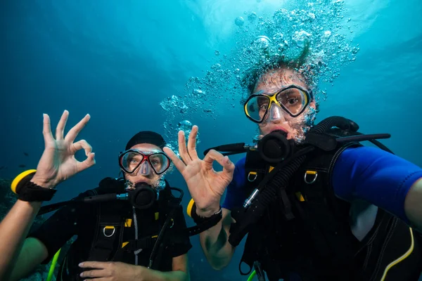 Scuba divers showing OK sign underwater — Stock Photo, Image