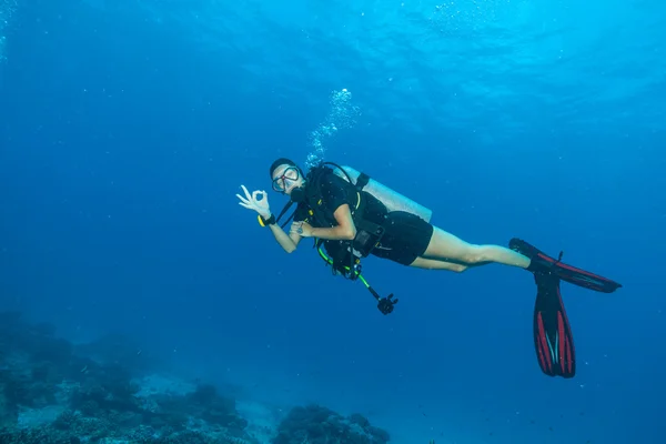 Молода жінка підводний дайвер, що показує знак ОК — стокове фото