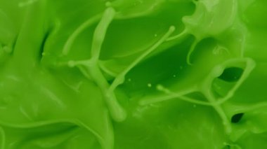 Yeşil boyanın çok yavaş sıçraması. Soyut arkaplan. Yüksek hızlı sinema kamerası, 1000 fps..