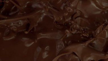 Koyu sıcak çikolatanın çok yavaş sıçratması. Sinema, yüksek hızlı kamera, 1000fps.