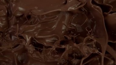 Koyu sıcak çikolatanın çok yavaş sıçratması. Sinema, yüksek hızlı kamera, 1000fps.