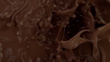 Koyu sıcak çikolatanın çok yavaş sıçratması. Sinema, yüksek hızlı kamera, 1000fps.
