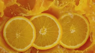 Portakal dilimlerinin çok yavaş bir şekilde meyve suyuna dökülmesi. Yüksek hızlı sinema kamerası, 1000 fps..