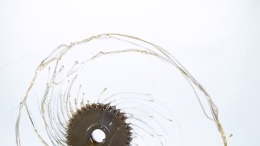 Super slow motion of rotating engine steel wheel with oil splashes on white background. Filmed on high speed cinema camera, 1000 fps.