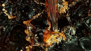 Splashing cola or ice tea, top view, studio shot