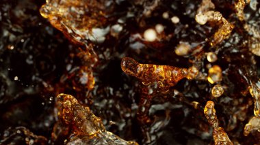 Splashing cola or ice tea, top view, studio shot