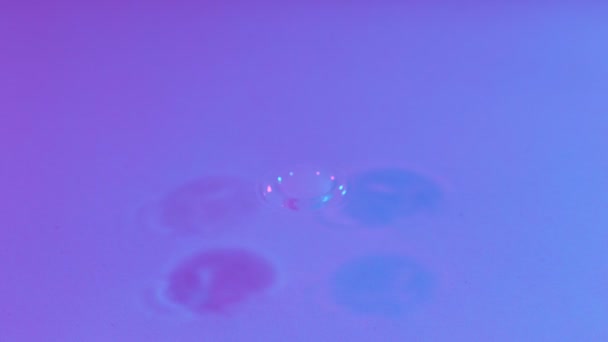 ネオンライトで照らされた水しぶきの超スローモーション 高速フィルムカメラで撮影しました — ストック動画
