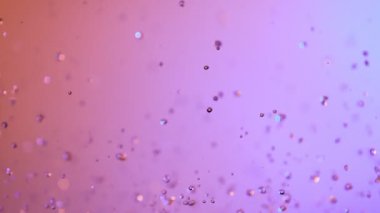 Neon ışıklarıyla aydınlatılmış su sıçratmanın süper yavaş çekimi. Yüksek hızlı sinema kamerası, 1000 fps..