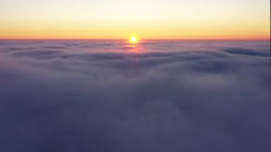 Gün doğarken bulutları aşarak, bulutların üzerinden uçarak gün doğumunda altın saat boyunca..