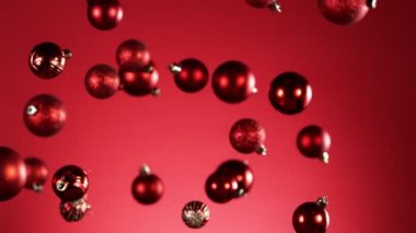 Renkli arka planda izole edilmiş uçan noel toplarının süper yavaş çekimi. Yüksek hızlı sinema kamerası, 1000 fps..