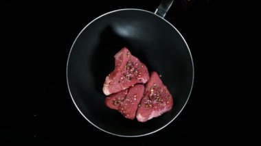 Tavada biftek ve siyah arka planda ateş patlaması. Çok yüksek hızlı sinema kamerası, 1000 fp..