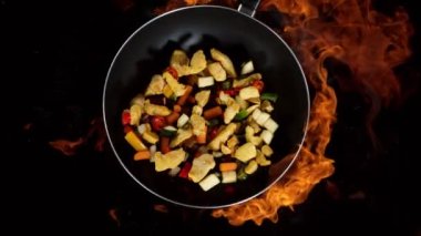 Tavadan sebzeyle uçan Asya tavuğu etinin süper yavaş çekimi. Yüksek hızlı sinema kamerası, 1000 fps..