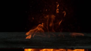 Siyah arka planda ateş olan boş ızgara ızgarasının süper yavaş çekimleri. Yüksek hızlı sinema kamerası, 1000 fps.