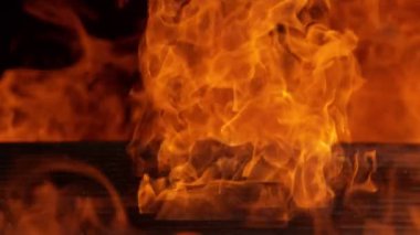 Siyah arka planda ateş olan boş ızgara ızgarasının süper yavaş çekimleri. Yüksek hızlı sinema kamerası, 1000 fps.