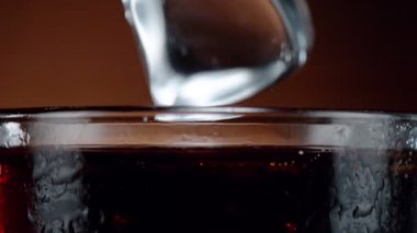 Buz küpünün kola içeceğine düşmesi çok yavaş bir hareket, kamera hareketi. Yüksek hızlı sinema kamerası, 1000 fps.
