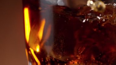 Buz küpünün kola içeceğine düşmesi çok yavaş bir hareket. Yüksek hızlı sinema kamerası, 1000 fps.