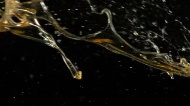 Siyah arka planda çok yavaş sıçrayan yağ. Yüksek hızlı sinema kamerası, 1000 fps.