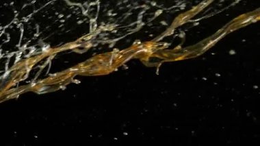 Siyah arka planda çok yavaş sıçrayan yağ. Yüksek hızlı sinema kamerası, 1000 fps.
