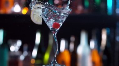 Buz küpünün kokteyl içeceğine düşmesi çok yavaş bir hareket, kamera hareketi. Yüksek hızlı sinema kamerası, 1000 fps..