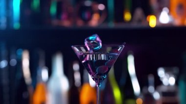 Buz küpünün kokteyl içeceğine düşmesi çok yavaş bir hareket, kamera hareketi. Yüksek hızlı sinema kamerası, 1000 fps..