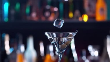 Buz küpünün kokteyl içeceğine düşmesi çok yavaş bir hareket, kamera hareketi. Yüksek hızlı sinema kamerası, 1000 fps..