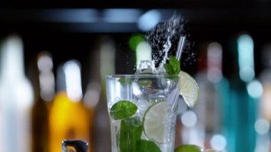 Mojito içeceğine düşen buz küpünün süper yavaş çekimi, kamera hareketi. Yüksek hızlı sinema kamerası, 1000 fps..