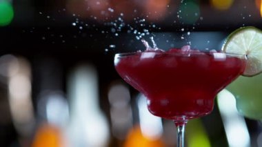 Buz küpünün kokteyl içeceğine düşmesi çok yavaş bir hareket, kamera hareketi. Yüksek hızlı sinema kamerası, 1000 fps..