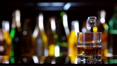 Buz küpünün viski içkisine dönüşmesi çok yavaş bir hareket, kamera hareketi. Yüksek hızlı sinema kamerası, 1000 fps..