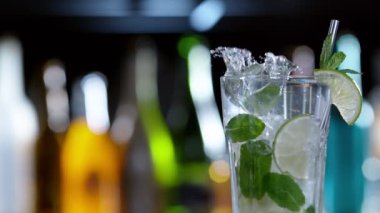 Mojito içeceğine düşen buz küpünün süper yavaş çekimi, kamera hareketi. Yüksek hızlı sinema kamerası, 1000 fps..