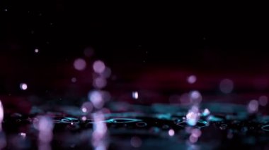 Neon ışıklarıyla aydınlatılan su dalgalarının süper yavaş akımı. Çok hızlı bir kamerayla çekildi, 1000 fps..