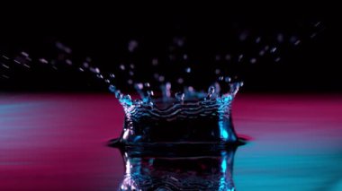 Neon ışıklarıyla aydınlatılan su kaplamasının süper yavaş çekimi. Çok hızlı bir kamerayla çekildi, 1000 fps..