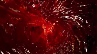 Kıvrımlı kırmızı şarabın çok yavaş bir şekilde dökülmesi. Yüksek hızlı sinema kamerası, 1000 fps..