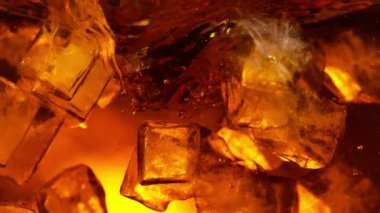 Kola ya da alkollü içecek içinde dönen buz küplerinin süper yavaş çekimleri. Yüksek hızlı sinema kamerası, 1000 fps..