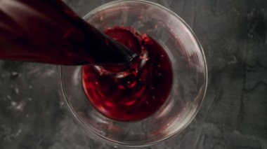 Kamera gücüyle kırmızı şarabı cama dökmenin süper yavaş çekimi. Yüksek hızlı sinema kamerası, 1000 fps..