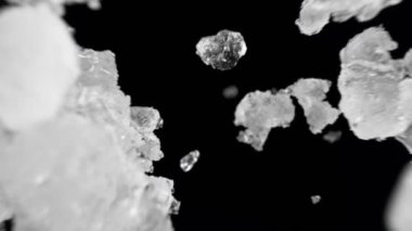 Düşen buz küplerinin süper yavaş çekimi siyah zemin üzerinde izole edildi. Yüksek hızlı sinema kamerası, 1000 fps..