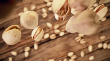 Ahşap arka planda düşen şam fıstığının süper yavaş çekimi. Yüksek hızlı sinema kamerası, 1000fps.