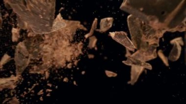 Siyah arka planda düşen bir grup çiğ çikolata parçasının süper yavaş çekimi. Yüksek hızlı sinema kamerası, 1000fps.