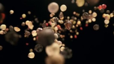 Siyah arka planda düşen renkli biber baharatının süper yavaş çekimi. Yüksek hızlı kamera, 1000 fps.