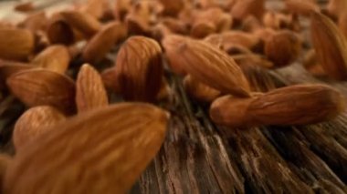 Tahtada yuvarlanan bademlerin süper yavaş çekimi. Yüksek hızlı sinema kamerası, 1000fps.