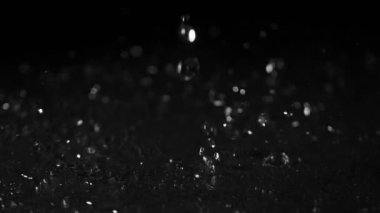 Siyah arka planda izole edilmiş çok yavaş su sıçratma hareketi. Yüksek hızlı sinema kamerası, 1000 fps..