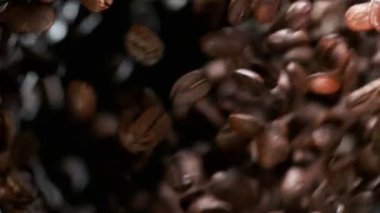 Uçan kahve çekirdeklerinin süper yavaş çekimi, makro çekim. Yüksek hızlı sinema kamerası, 1000 fps..