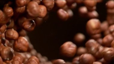 Dönen harekette uçan fındıkların süper yavaş çekimi. Yüksek hızlı sinema kamerası, 1000fps.