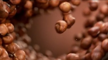 Dönen harekette uçan fındıkların süper yavaş çekimi. Yüksek hızlı sinema kamerası, 1000fps.